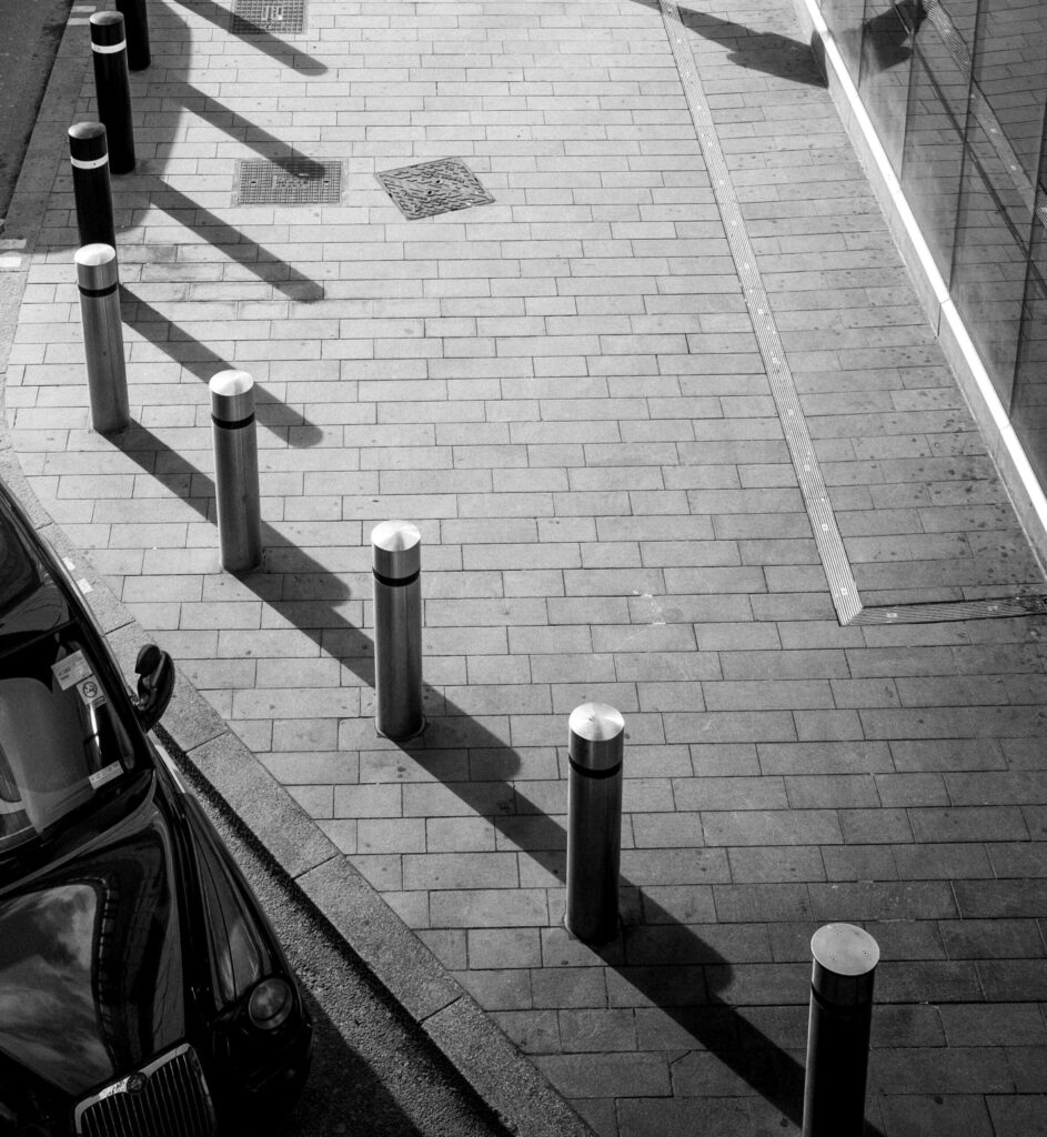 Stainless steel safety bollards installed along footpath to protect shopfront in Gippsland.